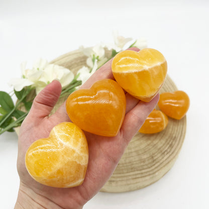 Polished heart shaped crystals in orange calcite stone